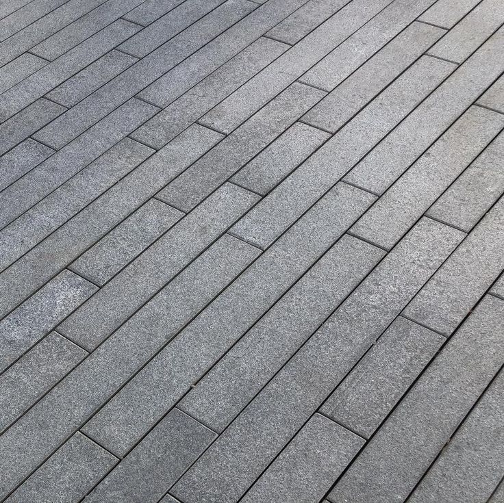 Black granite planks with deep black color and polished smooth finish, perfect for sleek and modern outdoor or indoor designs.