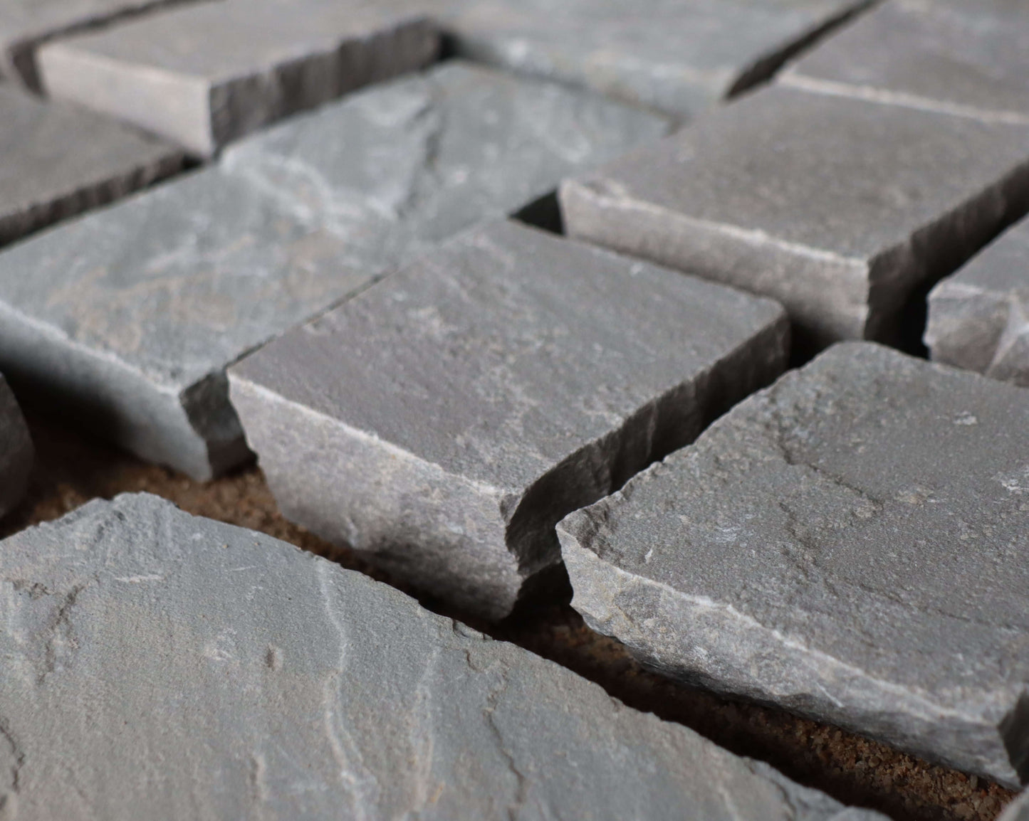 Kandla Grey cobblestones with rugged texture and natural grey shades, ideal for driveways, pathways, and rustic landscapes.