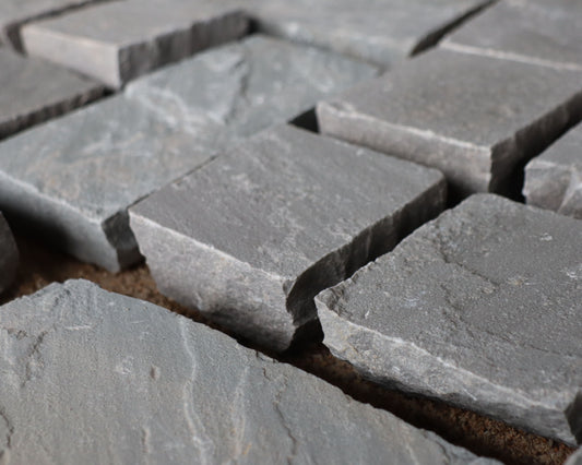 Kandla Grey cobblestones with rugged texture and natural grey shades, ideal for driveways, pathways, and rustic landscapes.