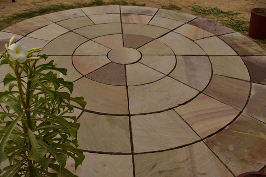 Circular paving stone in Rippon Buff color, featuring natural Indian sandstone texture and warm, earthy tones.